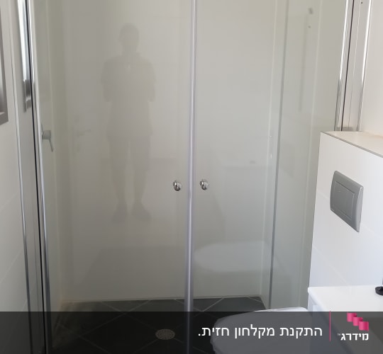 מקלחת עם דלת זכוכית ושירותים